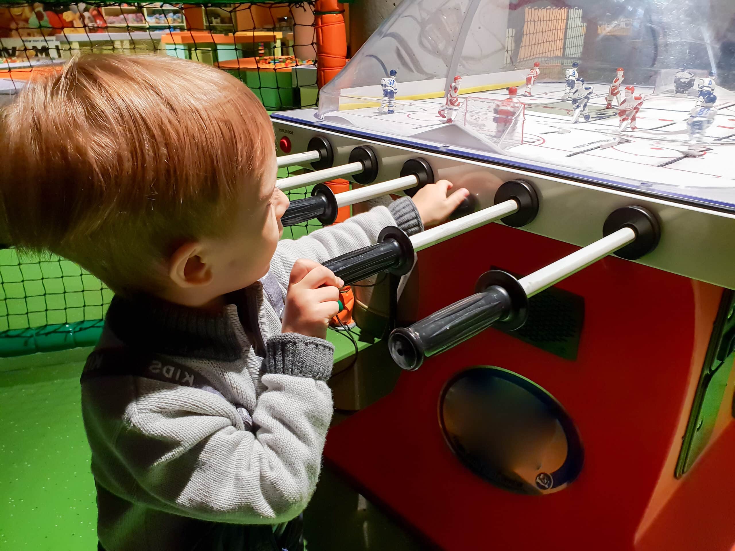 Portrait of toddler boy playing in table hockey